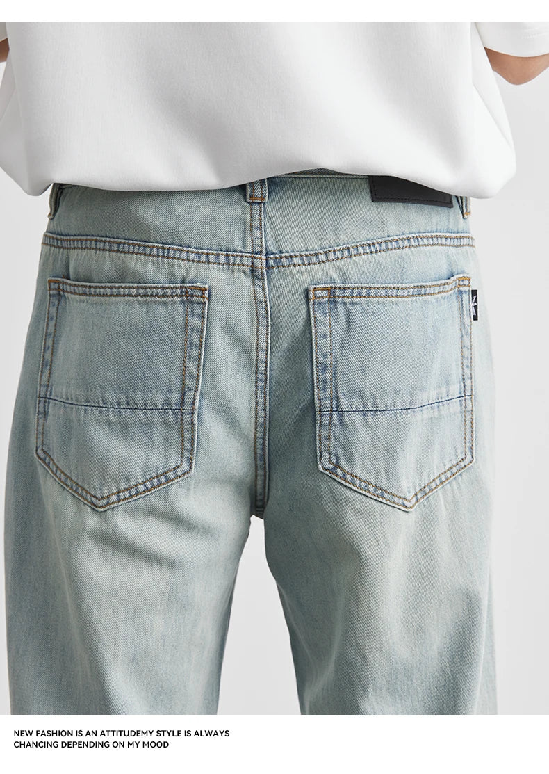 Light blue jeans with a white shirt on a plain background