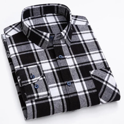 A folded long-sleeve plaid button-up shirt in black, white, and gray, with blue buttons, shown on a clean white background.