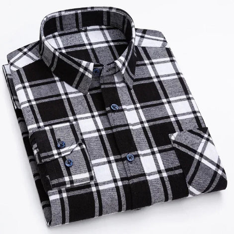 A folded long-sleeve plaid button-up shirt in black, white, and gray, with blue buttons, shown on a clean white background.