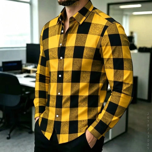 A man wearing a long-sleeve button-up shirt with a bold yellow and black buffalo check pattern, standing in an office environment.