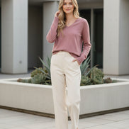 Woman wearing a pink sweater against a beige background