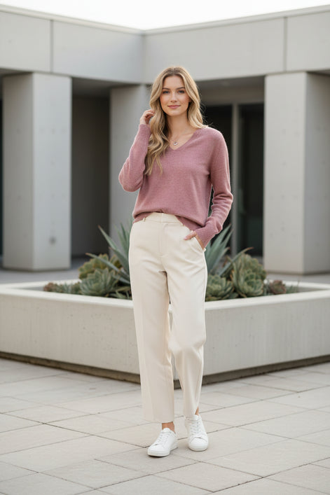Woman wearing a pink sweater against a beige background