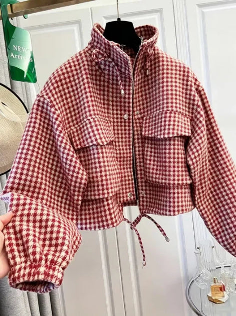 Red and cream checked utility jacket on a hanger, showing a raised collar, chest flap pockets, front zipper and snaps, elasticated cuffs and a drawcord hem