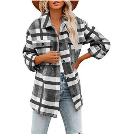 Woman wearing a gray and white plaid shirt with jeans, against a white background.