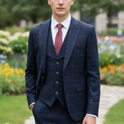 Navy checkered suit on a mannequin with a pink tie against a beige curtain background