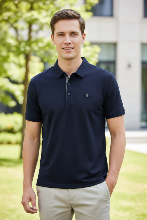Navy blue polo shirt on a hanger with a hand touching it, brand logo visible