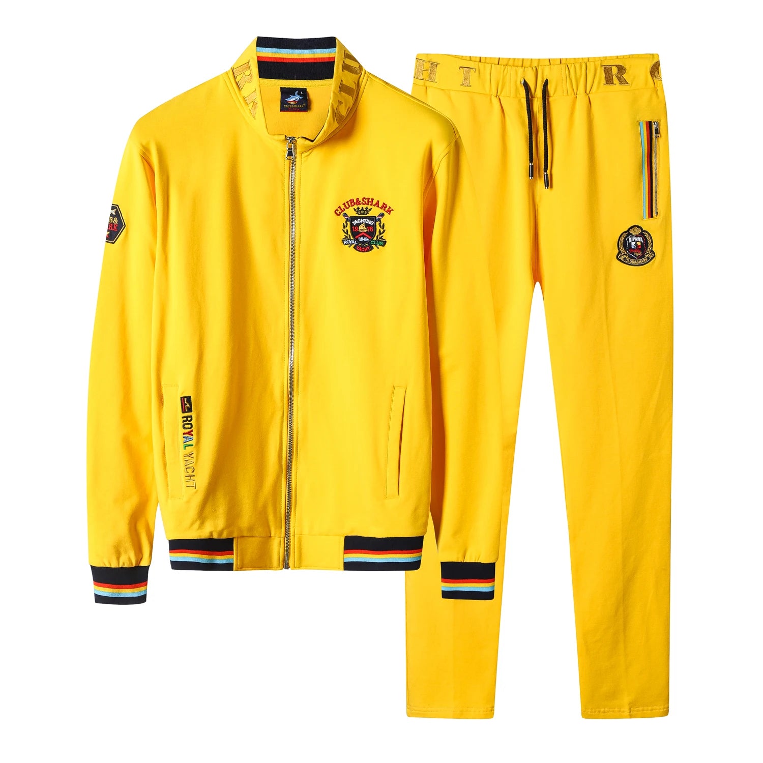 A bright yellow two-piece tracksuit set consisting of a zip-up jacket and matching pants, featuring multicolor striped ribbed cuffs and hem, a central crest logo on the chest, and side zipper pockets.