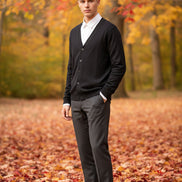 Black cardigan over a white shirt on a wooden hanger against a wooden panel background