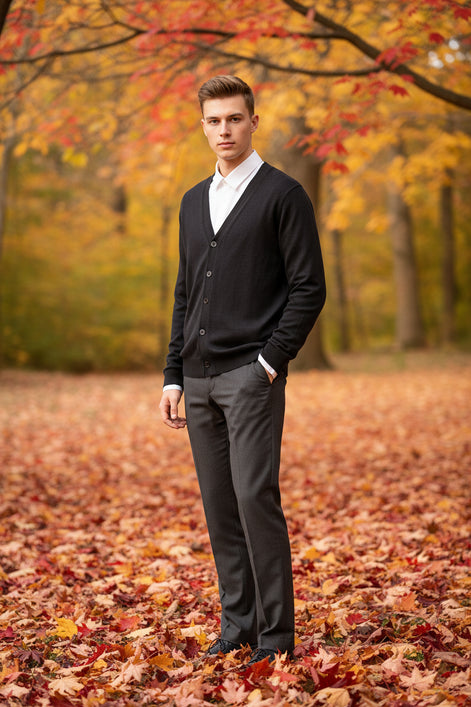 Black cardigan over a white shirt on a wooden hanger against a wooden panel background