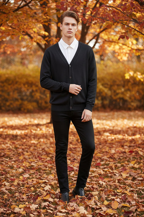 Black cardigan over a white shirt on a wooden hanger against a wooden panel background