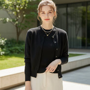 Black cardigan worn by a person with a neutral background