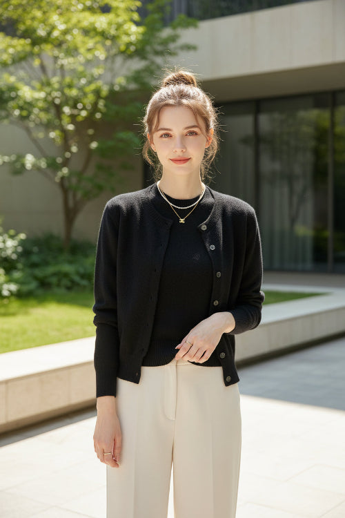 Black cardigan worn by a person with a neutral background