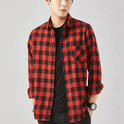 A man modeling a red and black plaid button-up shirt over a black t-shirt and dark jeans, set against a light gray background with promotional text overlays.