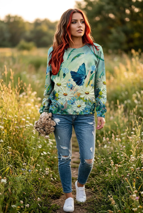 A woman wearing a long-sleeve crewneck sweatshirt with a vibrant 3D floral and butterfly print. 