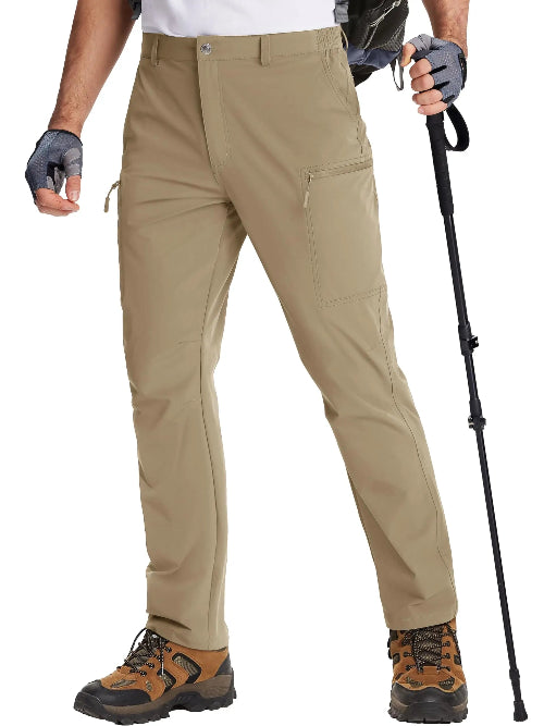 Person wearing beige hiking pants with hiking boots and a walking stick on a white background