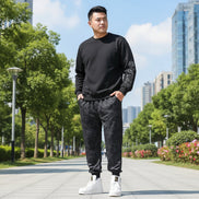 Person wearing black camouflage jogger pants and white sneakers on a gray background