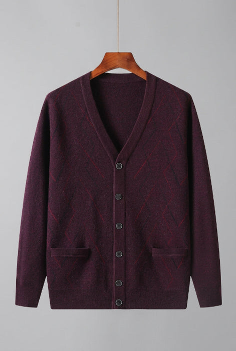 A men's knit cardigan sweater in a deep plum purple color, hanging on a wooden hanger against a white background. The cardigan features a V-neck, button-up front, and two front patch pockets.