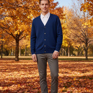 Blue cardigan over a white shirt on a wooden hanger against a wooden cabinet background.