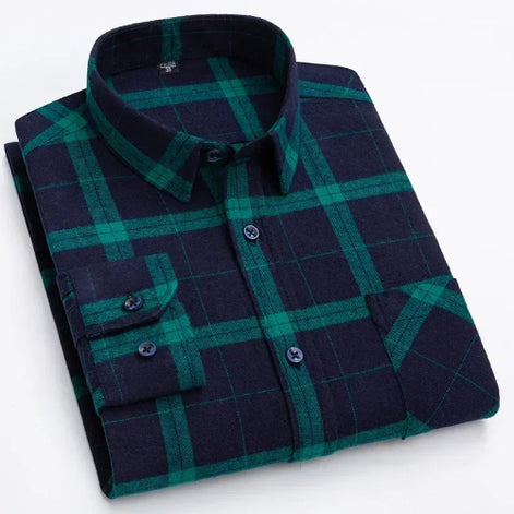 A folded long-sleeve button-up shirt with a dark navy and green plaid pattern, featuring a classic collar and a chest pocket with buttoned cuffs.