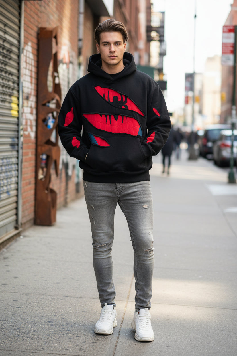 Black hoodie with red and blue graphic design on a gray concrete floor