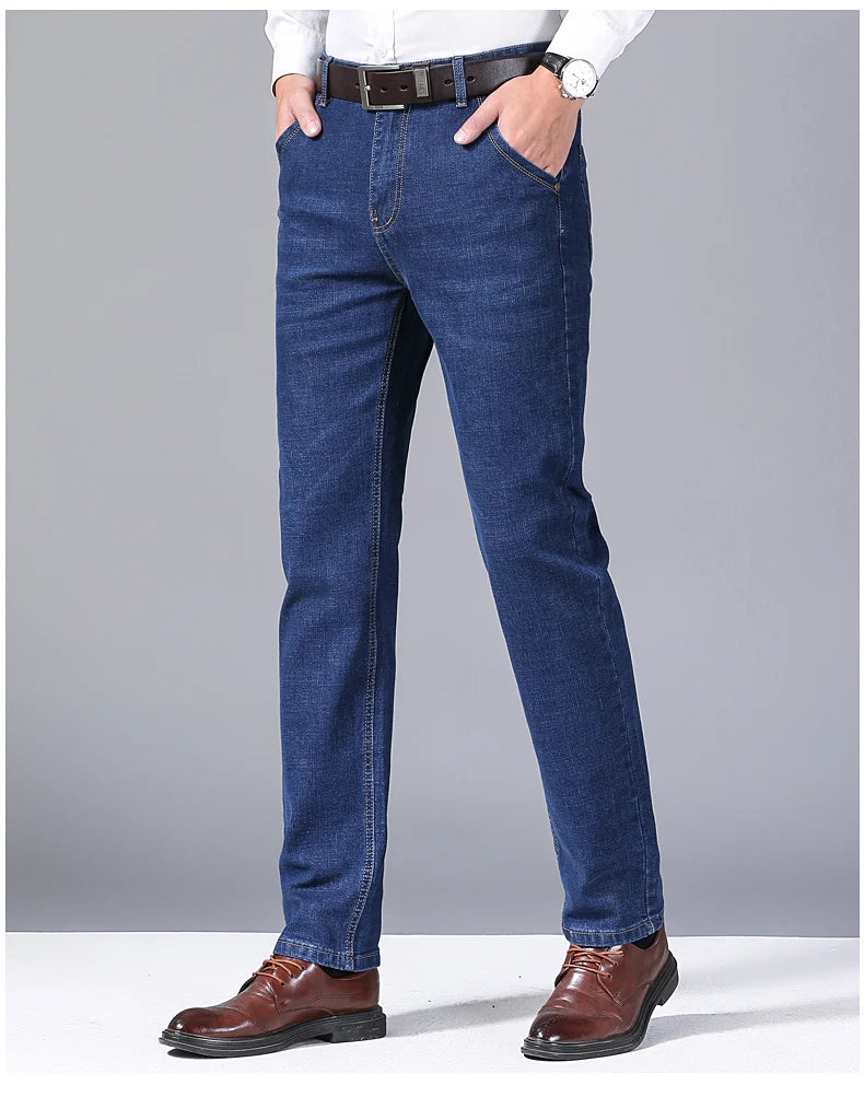 Person wearing blue jeans with a gray background