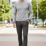Dark grey pants worn by a person on a gray background