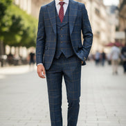 Blue checkered suit on a mannequin with a red tie against a brown curtain background