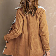 Back view of a woman wearing a tan jacket with white fleece-look trim, a center back seam and buckled cuffs