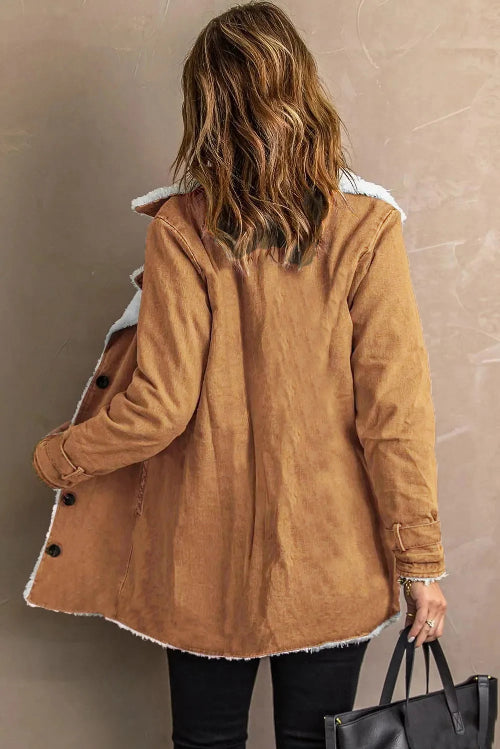 Back view of a woman wearing a tan jacket with white fleece-look trim, a center back seam and buckled cuffs