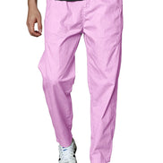 A person wearing light pink tapered pants with a black ribbed t-shirt and white sneakers, shown from the waist down 
