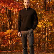 Black ribbed sweater with a zipper and a watch on a gray surface