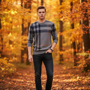 Person wearing a gray and black plaid sweater on a dark background
