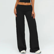 Person wearing black wide-leg pants on a plain background