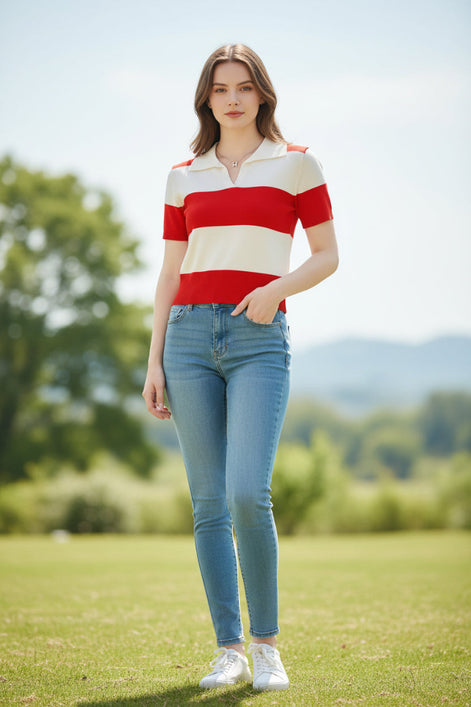 A woman wearing a short-sleeve knit polo shirt with bold horizontal red and off-white stripes, seated indoors against a dark brown leather surface.