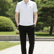 White polo shirt with a brand logo on a gray background