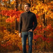 Folded dark gray sweater on a gray platform