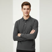 Gray polo shirt with a brand logo held by a hand, with other shirts in the background.
