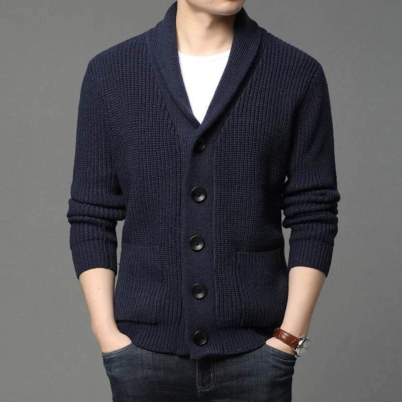 Navy blue cardigan worn by a person on a gray background