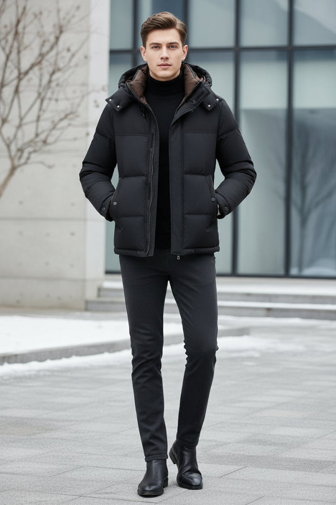 A man wearing a black puffer jacket with a brown-lined hood over a black turtleneck, shown against a dark gray background with feature callouts on the left.