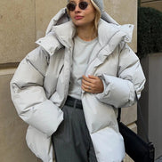 Person wearing a large white puffer jacket in an urban setting