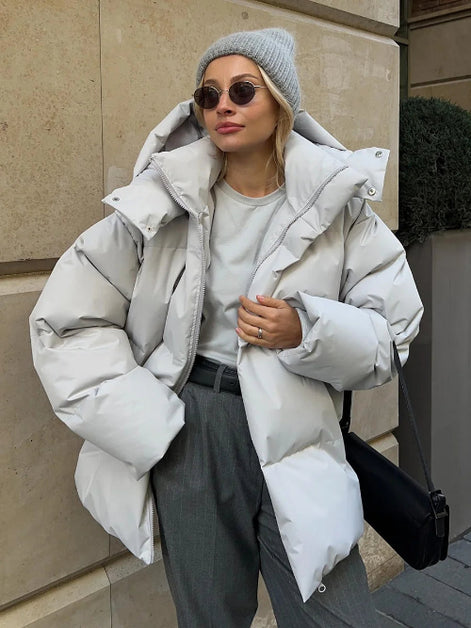 Person wearing a large white puffer jacket in an urban setting