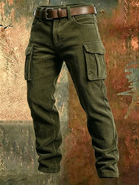 Olive green corduroy cargo pants with a brown leather belt, shown from the waist down against a textured, rustic brown and orange background.
