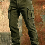 Olive green corduroy cargo pants with flap thigh pockets and a brown belt against a textured rust-colored metal background.