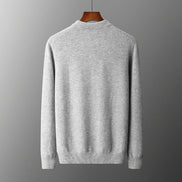 Gray sweater on a hanger against a gray background