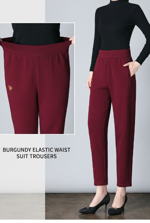 A model wears high-waisted burgundy suit pants with side pockets, paired with black heels. The image includes a close-up inset of the pants'