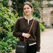 Person holding a Celine handbag in a store setting