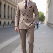 Beige double-breasted suit with a brown tie and pocket square against a blurred background