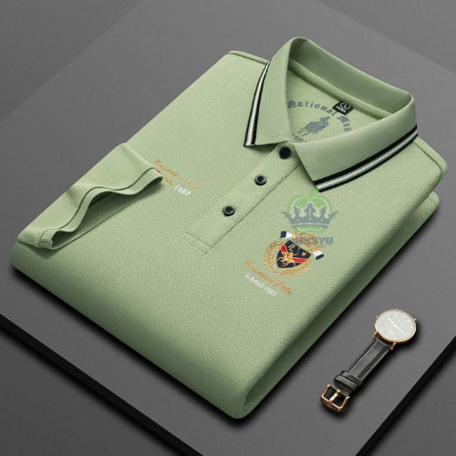Folded green polo shirt with a brand logo on a gray background