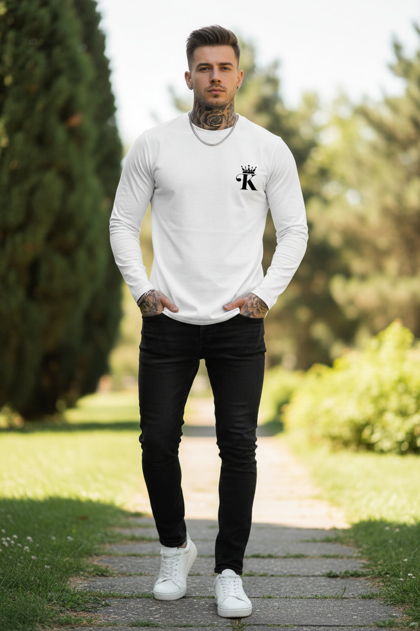 Person wearing a white long-sleeve shirt with an anchor design against a gray concrete wall.