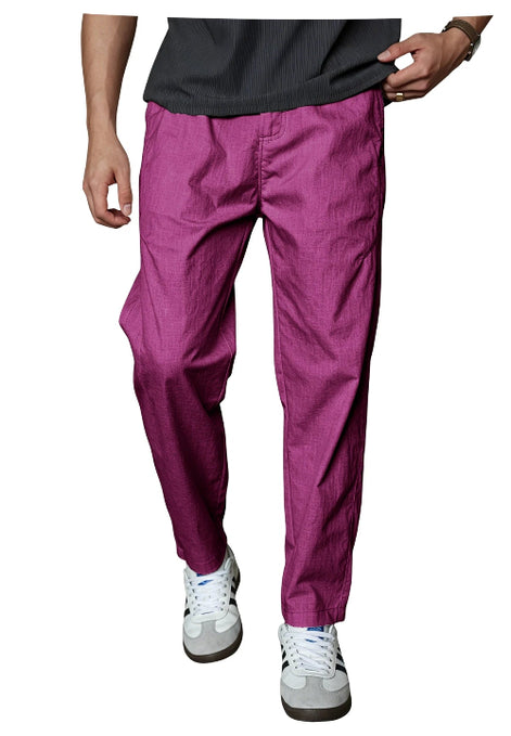 A person wearing bright magenta-purple cropped pants with a black top and white sneakers, 